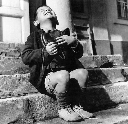 طفل نمساوي عمره 6 سنوات فرح بالحذاء الذي قدّمه له الصليب الأحمر خلال الحرب العالميّة الثانية